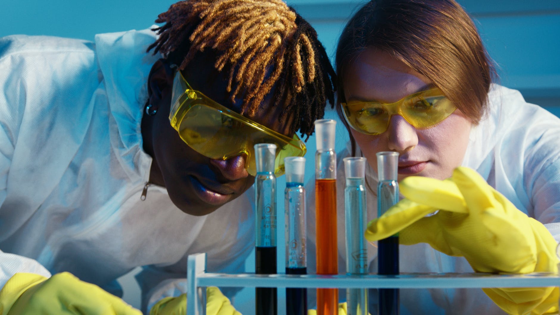 a man and a woman looking at the test tubes